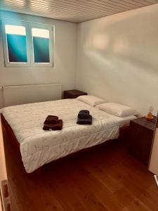 a bedroom with a bed with two hats and two windows at Le Chalet de la Coudre in Neuchâtel