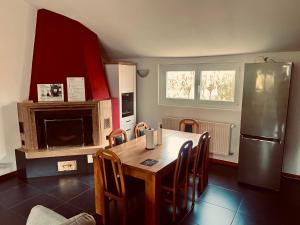 a kitchen with a wooden table and a refrigerator at Le Chalet de la Coudre in Neuchâtel