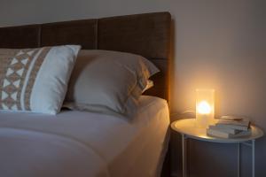 a bed with a night stand with a candle on it at TheaHouse in Pythagoreio