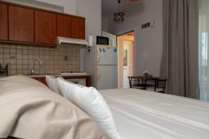 a bedroom with a white bed and a kitchen at TheaHouse in Pythagoreio