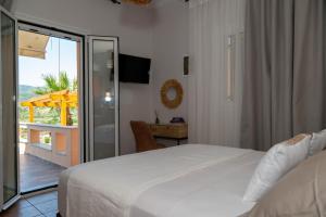 a bedroom with a bed and a sliding glass door at TheaHouse in Pythagoreio