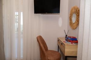 a room with a chair and a desk with a television at TheaHouse in Pythagoreio +35 photos