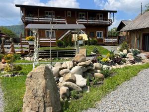a house with a rock garden in front of a house at Welcome to Карпати in Skole