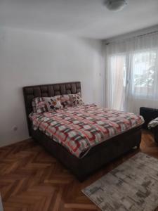 a bedroom with a bed with a quilt on it at Sladjana apartman in Prijepolje +7 photos