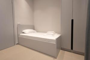a white room with a bed with towels on it at Aria Apartment 1 in Dhërmi