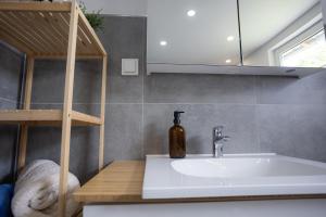 a bathroom with a sink and a bottle on a counter at Reload Apartments - FeWo1 im Remmeker Feld in Bad Arolsen