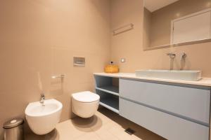 a bathroom with a toilet and a sink at Aria Apartment 1 in Dhërmi +14 photos
