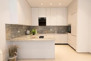 a kitchen with white cabinets and a counter top at Aria Apartment 1 in Dhërmi
