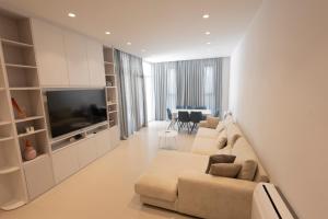 a living room with a couch and a television at Aria Apartment 1 in Dhërmi