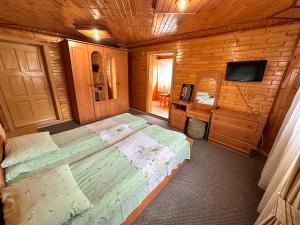 a bedroom with a large bed in a wooden room at Smerekova Hata in Yablunytsya