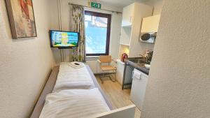 a small room with a bed and a tv in it at Aparthotel Marion Weber in Bremen