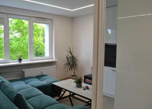a living room with a blue couch and a table at Žemaičių g apartamentai in Kretinga