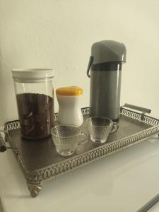 a tray with a coffee maker and cups on it at Quarto Privativo com ar condicionado no centro in Ribeirão Preto