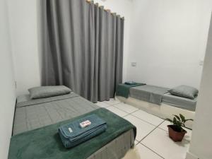 a bedroom with two beds and a bag on top of it at Quarto Privativo com ar condicionado no centro in Ribeirão Preto