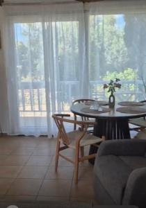 a table and chairs in a living room with a window at Myrtos Olive Seaside Villa in Myrtos