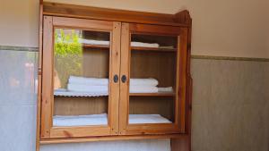a wooden cabinet with white towels in a bathroom at LUCIA s sweet Home in Padova