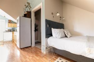 a bedroom with a white bed and a kitchen at Bluebird Day - Pine Hideaway in Bend