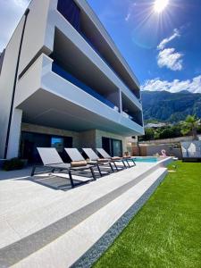 a house with a swimming pool and some chairs at Penthouse Jacuzzi SeaView Suite in Makarska