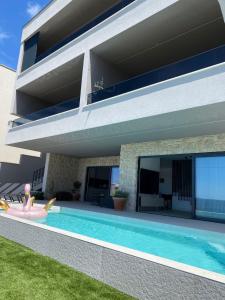 a house with a swimming pool in front of it at Penthouse Jacuzzi SeaView Suite in Makarska