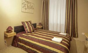 a bedroom with a bed and a window at Diófa Apartman Balatonederics in Balatonederics