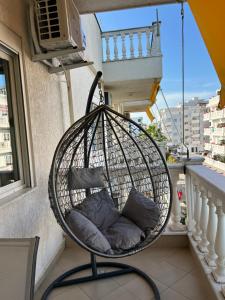 a hanging basket chair on a balcony with pillows at Garden view apartment in Karpen
