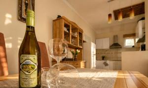 a bottle of wine sitting on a table with a wine glass at Diófa Apartman Balatonederics in Balatonederics