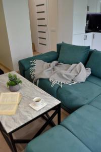 a living room with a green couch and a coffee table at Žemaičių g apartamentai in Kretinga +43 photos