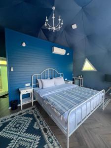 a blue bedroom with a bed and a blue wall at Chadir yurd glamp in İsmayıllı