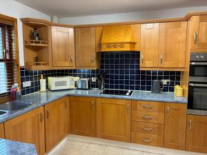 a large kitchen with wooden cabinets and appliances at Lotties Neuk in Lerwick