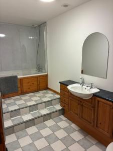 a bathroom with a sink and a tub and a mirror at Lotties Neuk in Lerwick