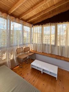 a bedroom with a bed and a chair and windows at SEAVIEW BG Beach Front Suites in Golden Sands +186 photos