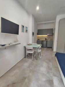 a living room with a table and a kitchen at SEA Studio Flat in Misano Adriatico