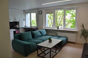 a living room with a blue couch and a table at Žemaičių g apartamentai in Kretinga
