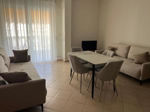 a living room with a couch and a table and chairs at Garden view apartment in Karpen