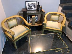 two chairs sitting in a room with a fireplace at Pousada Valley House in Piranhas