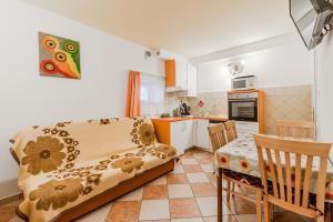 a living room with a couch and a kitchen at Guesthouse Sobe Silva in Tolmin