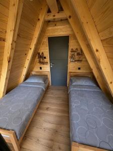 an attic bedroom with two beds in it at Vikendica Ema in Šipovo