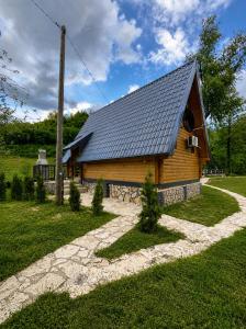 a log cabin with a black roof at Vikendica Ema in Šipovo