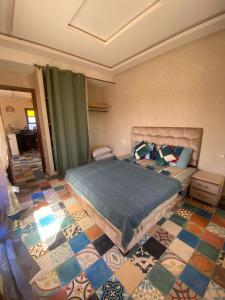 a bedroom with a bed and a tiled floor at Le domaine de Koujane in Oulad el Guern