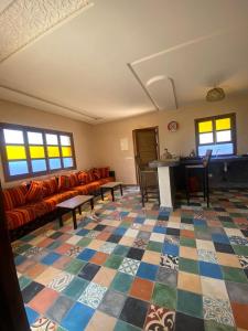 a living room with couches and a checkered floor at Le domaine de Koujane in Oulad el Guern