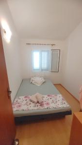 a bed in a room with a window at Apartman Ferri 3 in Vrbanj