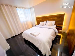 a bedroom with a bed with white sheets and a window at Hospedaje R&M in Pelileo