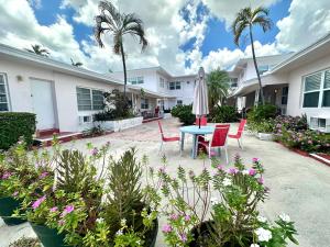 a patio with a table and chairs and palm trees at Birch Patio Motel in Fort Lauderdale