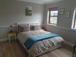 a bedroom with a bed with a blue blanket at Cnoc Sí 1 in Kilgarvan