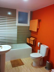 a bathroom with a toilet and a tub and a sink at Casa Bounty in Los Nietos