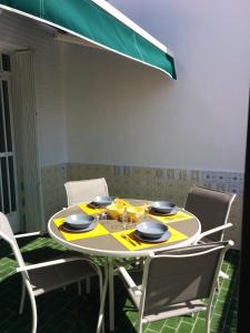 a dining room table with chairs and a yellow table cloth at Casa Bounty in Los Nietos