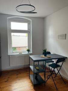a room with a black table and a window at Cityapartment Rosi in Pasewalk +4 photos