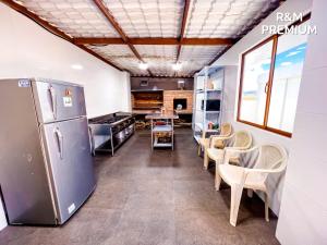a kitchen with a refrigerator and tables and chairs at Hospedaje R&M in Pelileo +12 photos