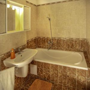 a bathroom with a white tub and a sink at Diófa Apartman Balatonederics in Balatonederics