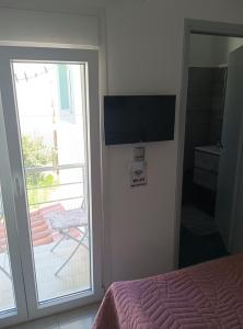 a bedroom with a bed and a sliding door with a balcony at Sophia in Kokkari
